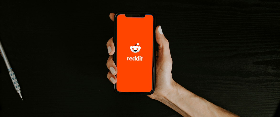 person holding phone with reddit app